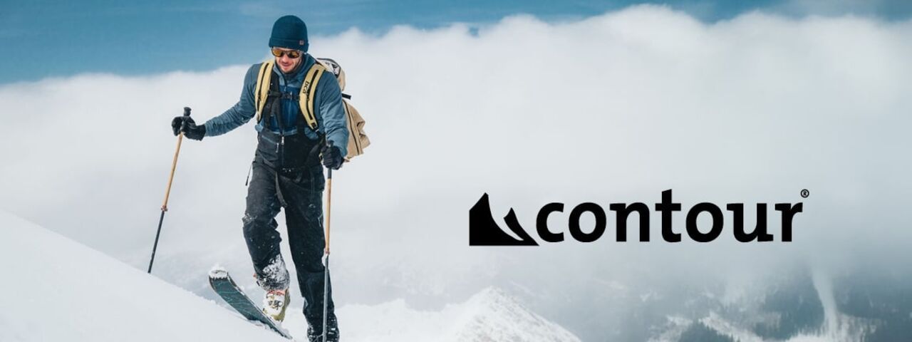 Skitourengeher mit Rucksack und Tourenski in verschneiter Berglandschaft – unterwegs mit Steigfellen von Contour.