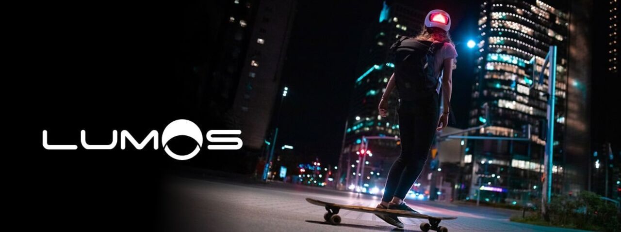 Skateboarderin mit beleuchtetem Lumos-Helm bei Nacht in der Stadt – smarte Sicherheit trifft urbanen Lifestyle.