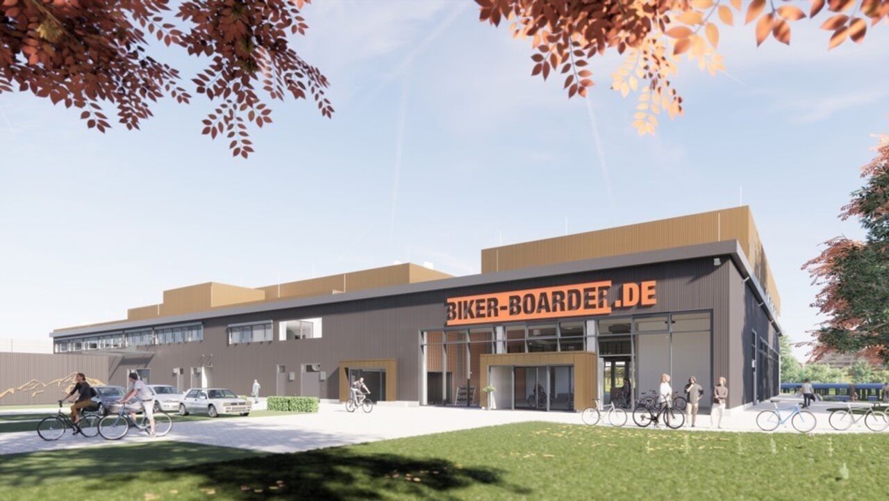 Modernes Firmengebäude von Biker-Boarder.de mit großem Eingangsbereich, Fahrrädern vor dem Gebäude und Besuchern bei sonnigem Herbstwetter.