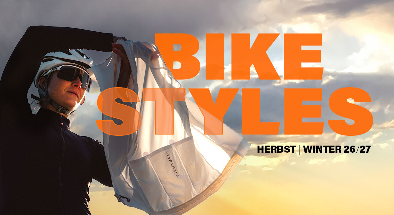 Bike-Sportlerin mit Helm, Jacke und Sonnenbrille vor herbstlichem Sonnenuntergang, Kampagnenmotiv für Bike-Styles Herbst/Winter 2026/27